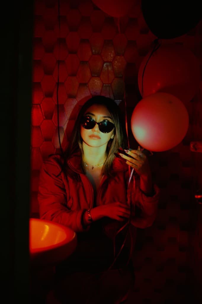 A woman in red sunglasses holding party balloons